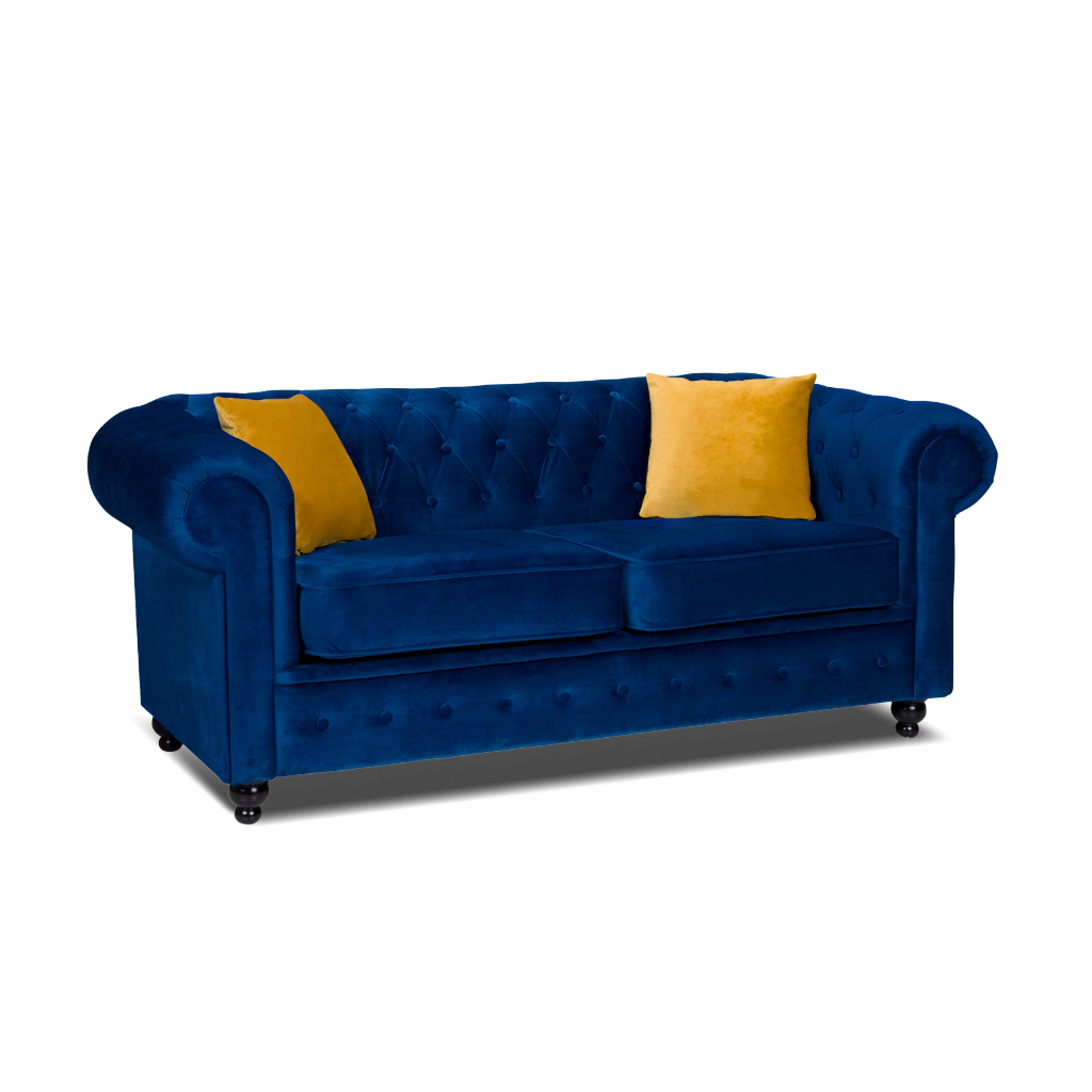 chesterfield 2 seater sofa plush velvet blue with 2 yellow pillow on the side www.furniturestop.co.uk